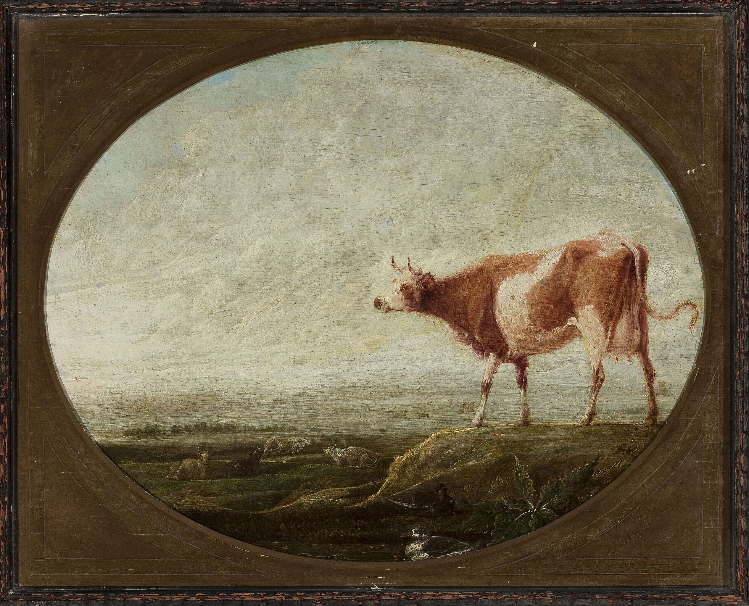 Een bruin-witte koe op de voorgrond met op de achtergrond een landschap met daarin nog enkele koeien. Het is bewolkt. Het zit in een rechthoekige houten lijst met in het midden een ovale uitsnede waarin het schilderij te zien is.
