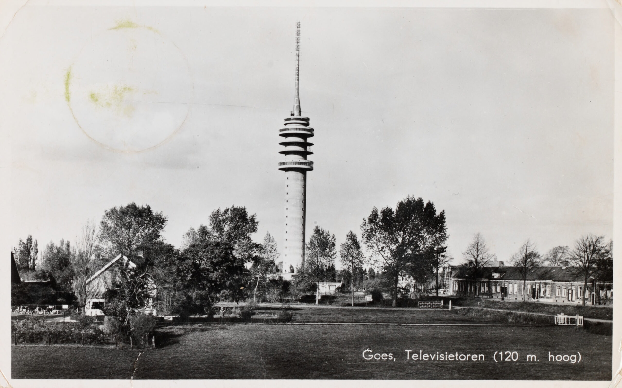 Een zwart-witte prentbriefkaart met daarop een 120 meter hoge toren in een landschap met wat bomen.